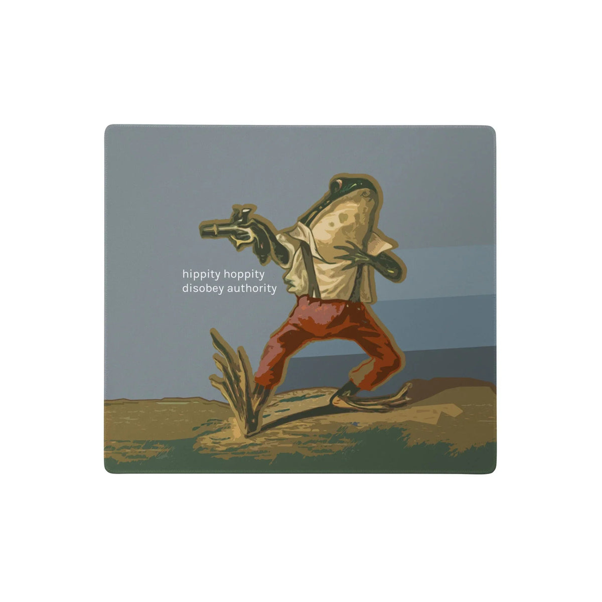 Hippity Hoppity Desk Mats - The lowercase sans-serif text "hippity hoppity disobey authority" juxtaposed with the central frog character aiming a handgun while dressed in rustic Terracotta Clay (#B84A3C) trousers, set against a Dry Earth Brown (#9A845A) and olive green landscape under a Stormy Slate (#808A8C) sky.